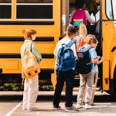 Children boarding school bus to public school.