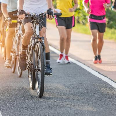 A group of cyclists and runners in their own lanes in the morning.