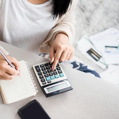 A woman calculating expenses and savings.