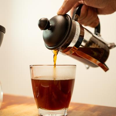 French press coffee being poured into a cup.