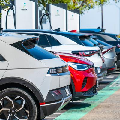 A row of different electric vehicles getting recharged at a station.