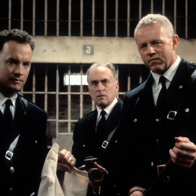 Tom Hanks (left) and David Morse (right) stands outside of a jail cell with two guards in a scene from the film 'The Green Mile', 1999.