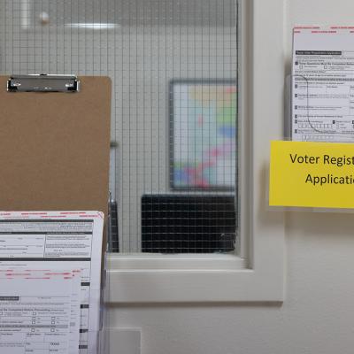 Voter registration applications hang in a rack at a Texas county elections office in 2024.