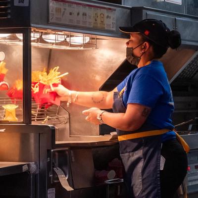 View of the back of a McDonalds worker at fry station.