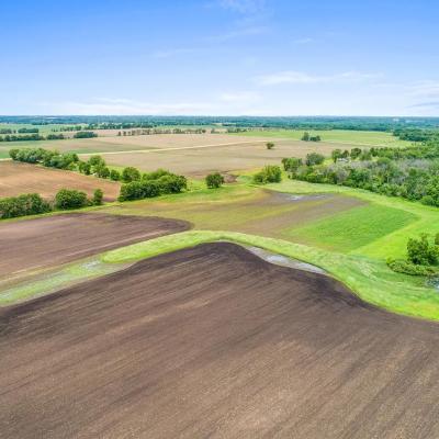 Aerial view of farmlands, soil, with blue sky in background.