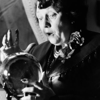 A fortune teller in London's Piccadilly is surprised at what she sees in a crystal ball, circa 1953. 