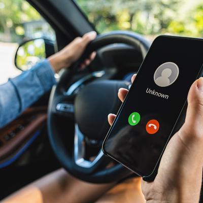 Person inside a car looking at an incoming unknown call.