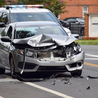 A car is smashed due to accident with police in the background in Alexandria, VA.