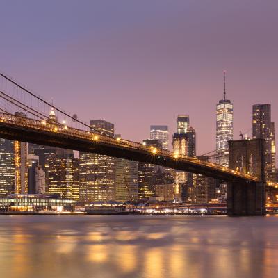 Brooklyn Bridge and Lower Manhattan skyline at dawn in New York City.