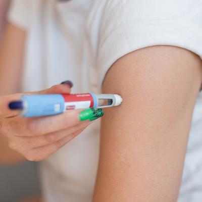 Person using a weight loss injectable on arm at home.