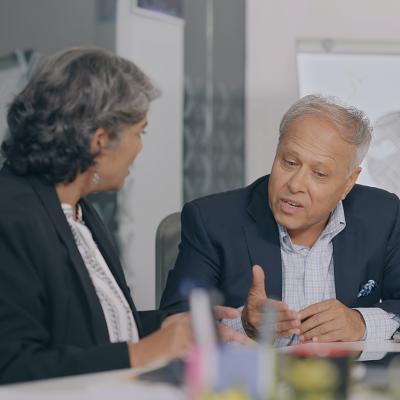 Senior male professional engaged in an intense conversation with coworker.