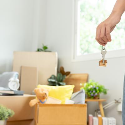 Person holding house keys while seemingly staring at moving boxes and packed items.