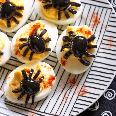 Deviled eggs with spiders made of olives for Halloween.