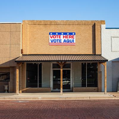 An election polling station with a "Vote Here"/"Vote Aqui" sign.