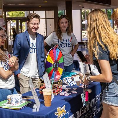 Students help staff the voter registration table in the student center of The College of New Jersey.