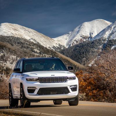 A white 2025 Jeep Grand Cherokee Summit Reserve SUV on the road.