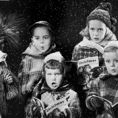 Four children singing carols, from a caroling book entiled 'Christmas, Its' Carols, Customs and Legends,' circa 1955.