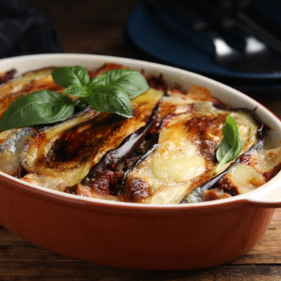 Freshly-baked eggplant lasagne in a red baking dish