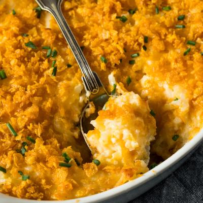 Homemade funeral potatoes casserole with cheese and chives.