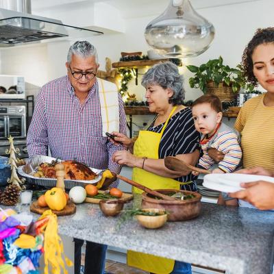 Multiple generations of a Latine family cooking together in the kitchen for the holidays.