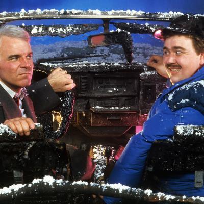 Actors Steve Martin and John Candy in 'Planes, Trains & Automobiles' Steve Martin and John Candy sit in a destroyed car in a scene from the 1987 film 'Planes, Trains & Automobiles.'