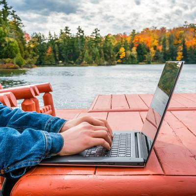 A remote worker using a laptop outdoors.