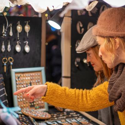 Two women shopping for jewelry at a Christmas market