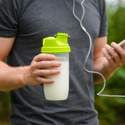 Man on an exercise holding a bottle of supplemental drink.