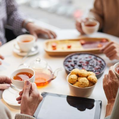 Seniors drinking tea together at a table.