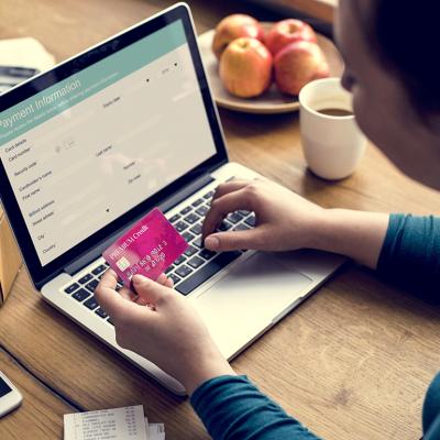 A woman using her credit card to pay for online shopping.