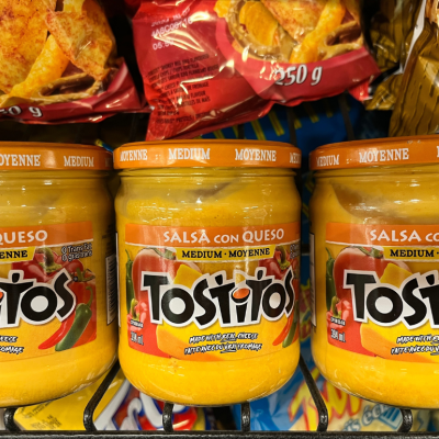 Jars of Tostitos Salsa Con Queso on a supermarket shelf