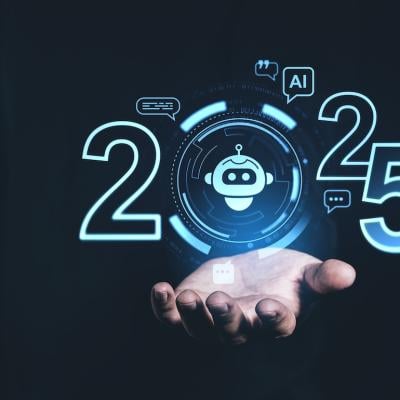 A person holding up a digital display showing AI trends for 2025.