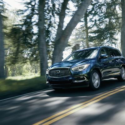 Blue 2020 INFINITI QX60 driving on the road.