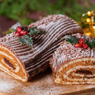 Traditional Christmas chocolate yule log with festive decorations.