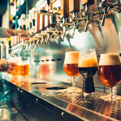 View of bartender pouring different types of beer on tap.