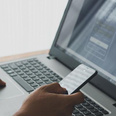 Person setting up a two-factor authentication login using a laptop and a phone.