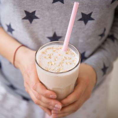 A woman holding a glass of blended oats drink. Oatzempic is one of the viral weight loss hack trends of the past year.