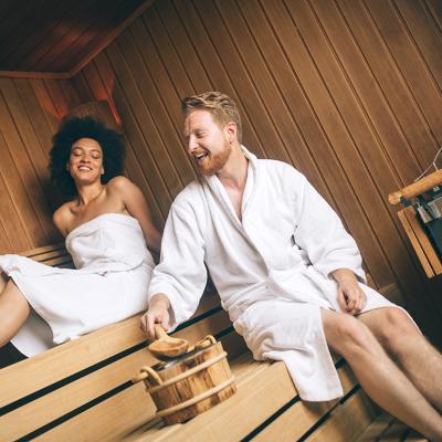 Young happy couple relaxing inside a sauna at a luxury hotel spa.