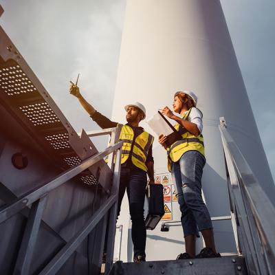 Two wind turbine technicians inspecting a site. 