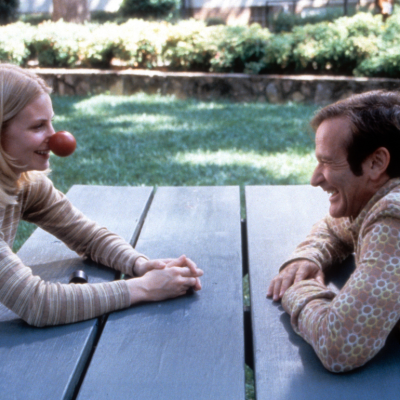 Monica Potter sits with Robin Williams in a scene from the film 'Patch Adams', 1998.