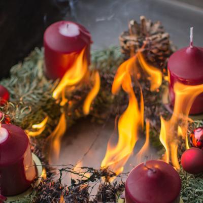 A Christmas wreath getting caught on fire from candles.