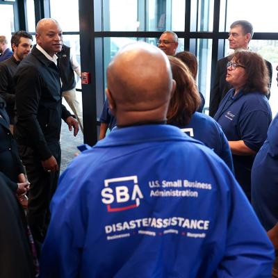 Workers at the Small Business Administration’s Business Recovery Center in Maryland talking to Governor Wes Moore.