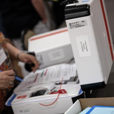 Poll workers return voting equipment to central county station workers. 