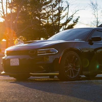 A black Dodge Charger HEMI with tinted windows in the parking lot.