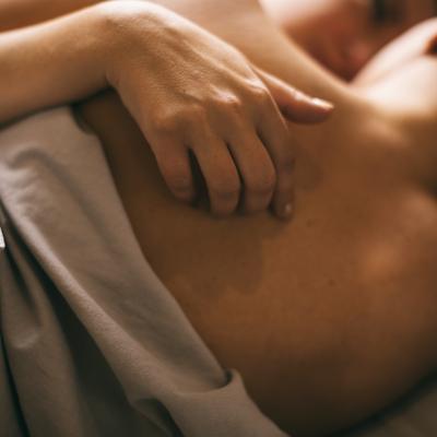 A queer couple share a tender intimate moment in bed.