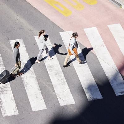 Traveling corporate professionals crossing a street. 