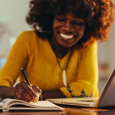 A woman exercising selective focus and taking notes in an agenda.