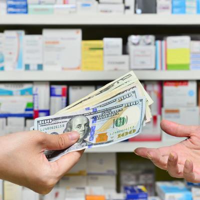 A customer purchasing at the pharmacy with cash.