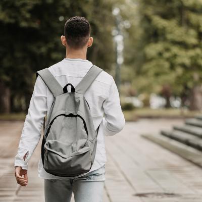 Photographed from behind, a young student walking in university.