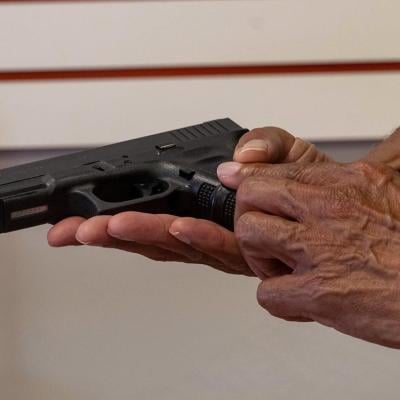 A certified firearms trainer in Lithonia, Georgia, holds a Glock 22 that was formerly a police gun.